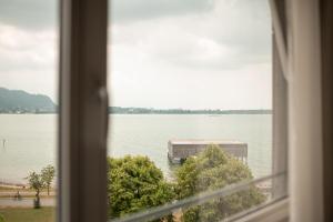 una ventana con vistas a un gran cuerpo de agua en Seehotel am Kaiserstrand en Lochau