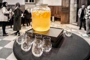 a jar of orange juice and glasses on a table at HOSTELLERIE CHARLES de FOUCAULD in Viviers