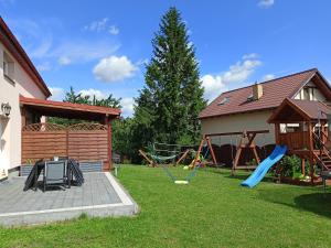 a yard with a playground and a house at Apartament Nad Jeziorem Ewa in Nadole