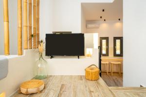 uma sala de estar com uma televisão de ecrã plano na parede em Ios Seaside house with sunset view and small pool em Chora, Ios