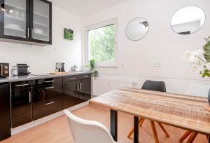 a kitchen with a wooden table and chairs at Green Apartment for 4 - Essen, Kitchen, WIFI, Netflix in Essen
