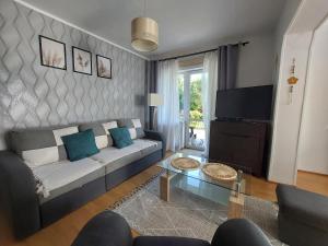 uma sala de estar com um sofá e uma televisão em Pokoje gościnne Na Klifie em Jastrzebia Gora