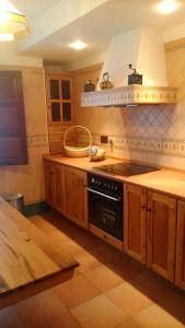 a kitchen with wooden cabinets and a stove top oven at Casa Rural La Huerta in Riaño