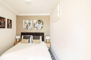 1 dormitorio con 1 cama blanca grande y 2 lámparas en New Luxury Loft-La fenêtre verte, en Roma