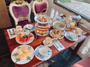 una mesa con platos de comida y tazas. en Xin Yuan My Dream Castle, en Dongshan