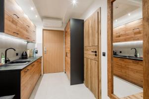 a kitchen with wood paneling and a door leading into a kitchen at Górskie Szczyty Apart & SPA Apartament 2 Sauna Jacuzzi i Parking w cenie in Zakopane