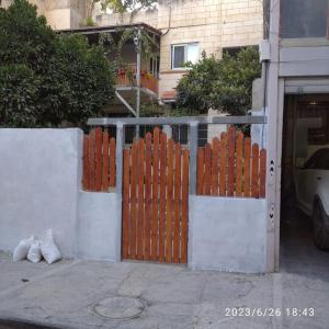 een hek met een oranje poort voor een gebouw bij حنضلة درويش in Bethlehem