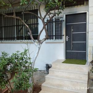 een zwarte deur op een wit huis met een trap bij حنضلة درويش in Bethlehem