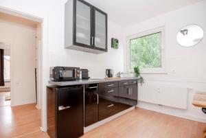 a kitchen with a black refrigerator and a window at Green Apartment for 4 - Essen, Kitchen, WIFI, Netflix in Essen