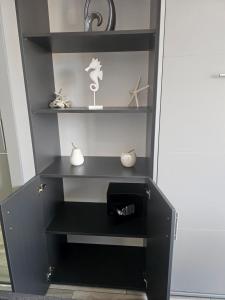 a black shelf in a room with some items on it at Marina Cape surprise studio in Aheloy +34 photos