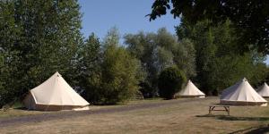 a group of tents in a field with trees at Rivers View Holidays in Westbury on Severn