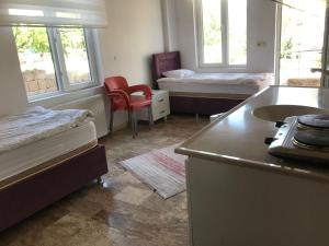 um quarto com 2 camas e uma cozinha com um lavatório em KAPADOKYA DELUXE APART em Ürgüp