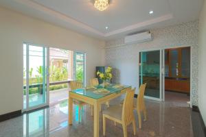 a dining room with a wooden table and chairs at June Pool Villa in Krabi
