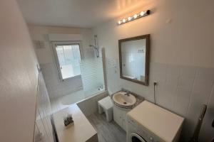 a white bathroom with a sink and a mirror at Bright cocoon with garden in the heart of La Baule in La Baule