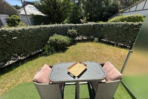 a table and chairs with a book on top of it at Bright cocoon with garden in the heart of La Baule in La Baule