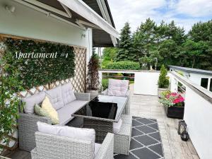 a patio with a couch and a table and chairs at Apartamenty 72 - Agroturystyka in Wola Pękoszewska