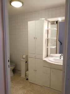 uma casa de banho branca com um lavatório e um WC em L'OUSTAL DE FLO em Florensac