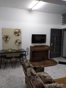 een woonkamer met een bank en een flatscreen-tv bij حنضلة درويش in Bethlehem