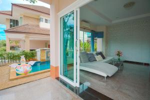 a living room with a bed and a swimming pool at June Pool Villa in Krabi