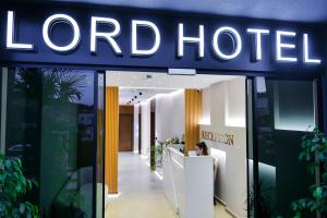 The Lord Hotel في كساميل: امرأة تجلس في كونتر أمام الفندق