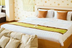 een slaapkamer met 2 bedden met gele en witte lakens bij June Pool Villa in Krabi town