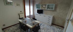 eine Küche mit einem Tisch und einer weißen Kommode mit einem TV in der Unterkunft Primetta House in Florenz
