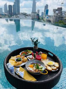 una bandeja de comida en una mesa junto a una piscina en Paradise Saigon Boutique Hotel & Spa en Ho Chi Minh