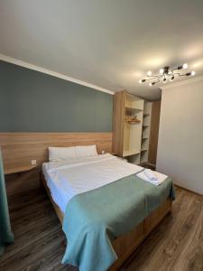 1 dormitorio con 1 cama grande con manta azul en White house Dsegh, en Tumanyan