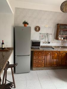 a kitchen with a white refrigerator and wooden cabinets at Casa Nehuna in Orzola