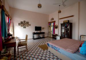 a bedroom with a bed and a table and a desk at Kol Pol Mohalla Boutique Stay in Udaipur