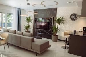 a living room with a couch and a tv at THE VIEW Premium Villas in Bar