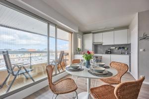 een keuken en eetkamer met een tafel en stoelen bij Le Tikahupo - Charmant appt vue sur le port in Courseulles-sur-Mer