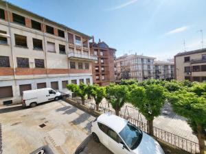 ein weißer Van auf einem Parkplatz neben Gebäuden geparkt in der Unterkunft Apartamento del Puente in Autol