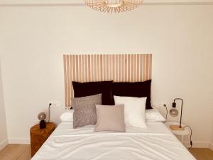a bedroom with a bed with white sheets and pillows at Victoria's Home modern and cosy 2 bedroom apartment in Málaga
