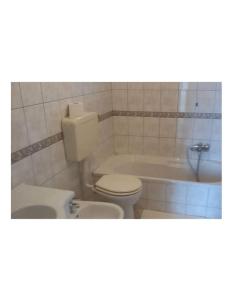 uma casa de banho com um WC, uma banheira e um lavatório. em Monolocale vista mare em Sciacca
