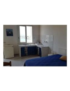 1 dormitorio con 1 cama azul y cocina en Monolocale vista mare, en Sciacca