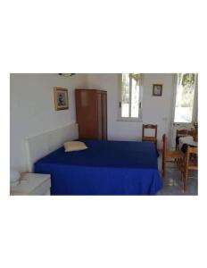 1 dormitorio con 1 cama con colcha azul en Monolocale vista mare, en Sciacca