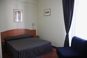 a bedroom with a bed and a chair and a window at B&B Luna Blu in Modica