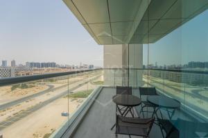 a balcony with chairs and tables on a building at KeyHost - Large 2BR Apartment in Dubai Science Park - Mont Rose - K860 in Dubai