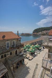 uma praia com um monte de guarda-sóis e um grupo de pessoas em Piazza Apartments 2 em Petrovac na Moru