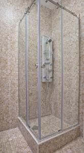 La salle de bains est pourvue d'une douche avec une porte en verre. dans l'établissement Piazza Apartments 2, à Petrovac na Moru