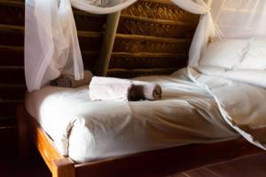 two beds with white sheets and towels on them at Singila Ocean Lodge in Inhambane