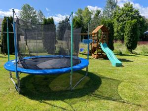 um parque infantil com um trampolim na relva em Felągówka em Murzasichle