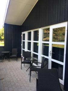 un patio con sillas, mesas y ventanas en Lerbæk Fiskepark, en Frederikshavn