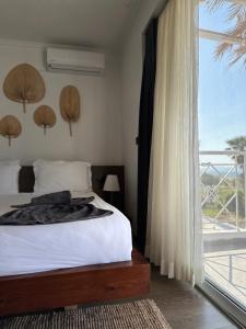 a bedroom with a bed and a large window at Li Mango in Tigaki
