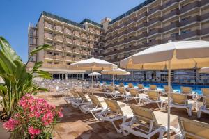 a row of chairs and umbrellas in front of a hotel at htop Amatista #htopBliss in Lloret de Mar