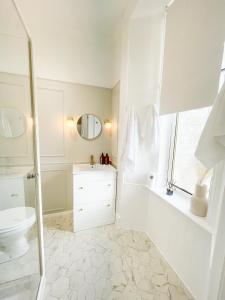 Baño blanco con lavabo y aseo en Kenavara House, en Oban