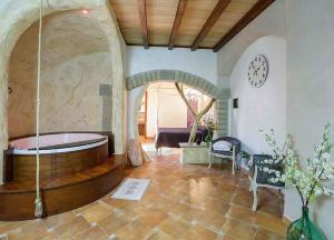 Habitación grande con bañera y reloj en la pared en Il Giardino dei Flintstones B&B en Cerveteri