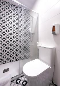 a bathroom with a toilet and a glass shower at Hostal Arenal Madrid in Madrid