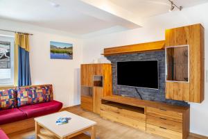 a living room with a couch and a flat screen tv at Haus Alpenheim Apartment 3 in Tux